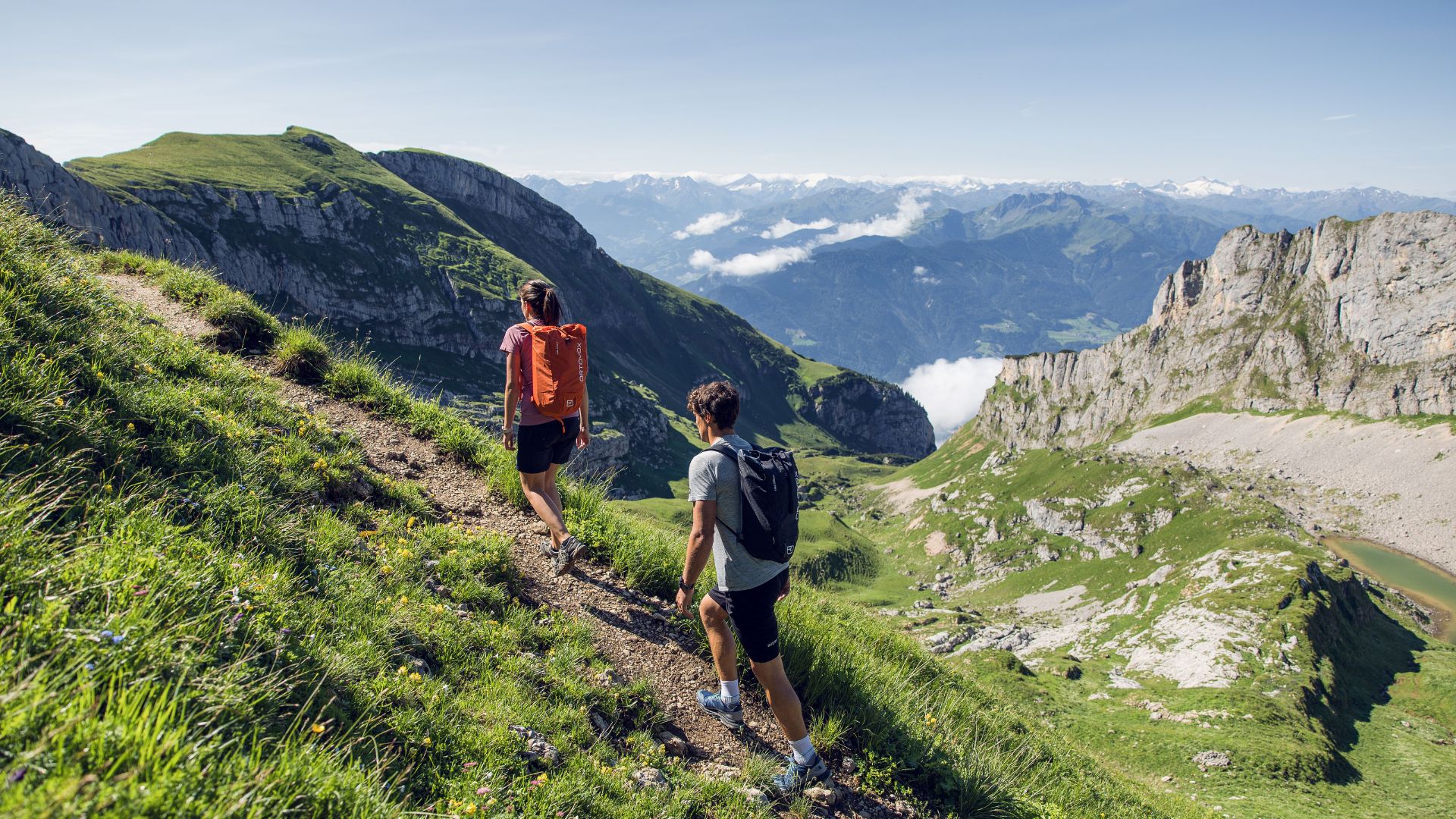 Zwei Wanderer auf aussichtsreichem Höhenweg in den Alpen oberhalb des Achensees mit Panoramablick auf Bergketten.